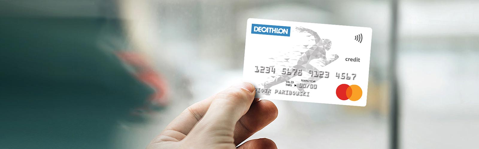 męskie palce trzymają kartę decathlon