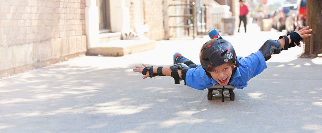 Dziecko jedzie na deskorolce na brzuchu