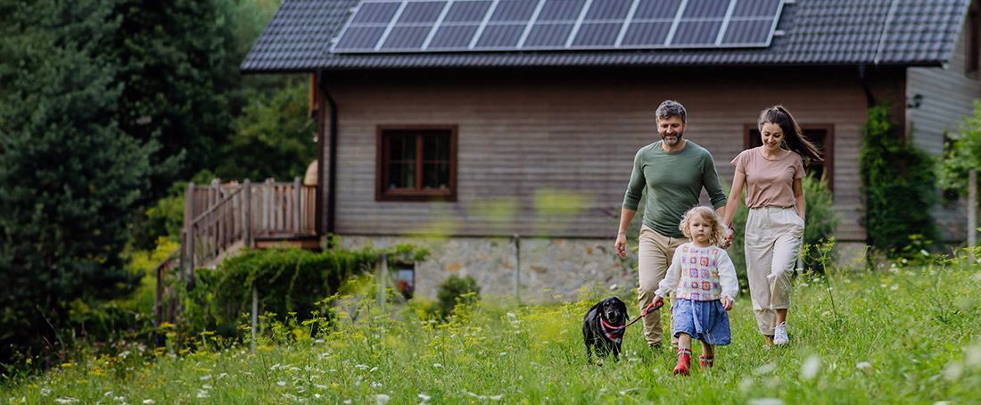 trzyosobowa rodzina idzie ogrodem z wysoką trawą