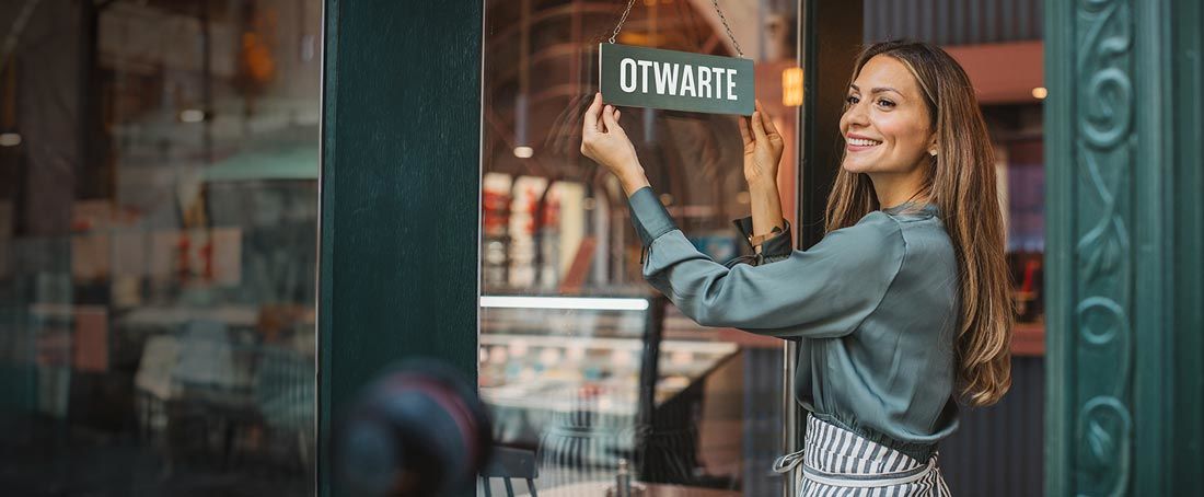 uśmiechnięta kobieta otwiera sklep
