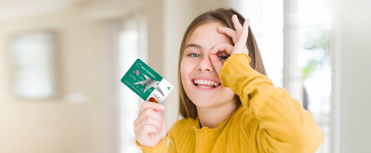 dziewczynka w żółtej bluzce trzyma kartę uśmiechając się