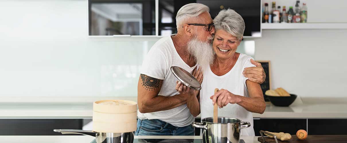 uśmiechnięta kobieta i mężczyzna gotują razem