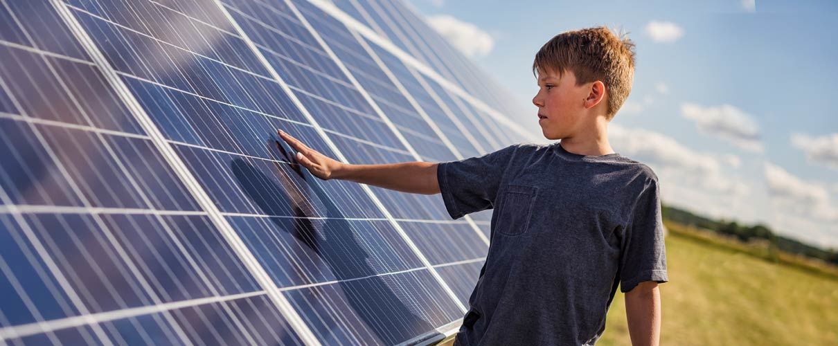 Chłopiec dotyka paneli fotowoltaicznych