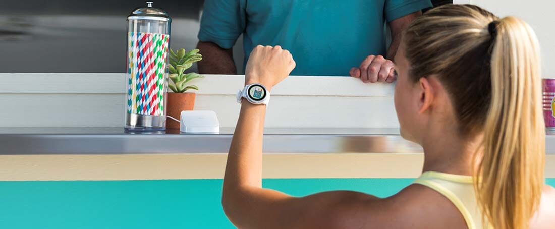 kobieta płaci za zakupy z wykorzystaniem zegarka i usługi Garmin Pay