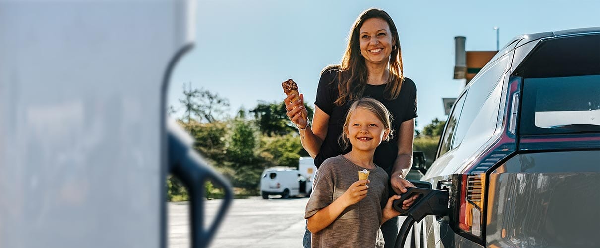 kobieta z córką tankują samochód jedząc lody