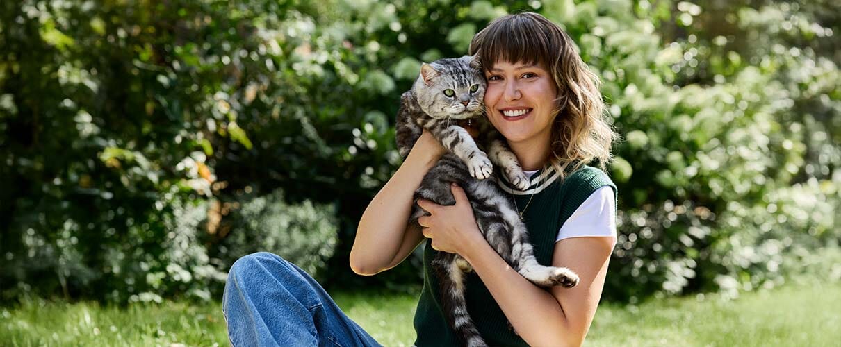dziewczyna na łące przytula kota