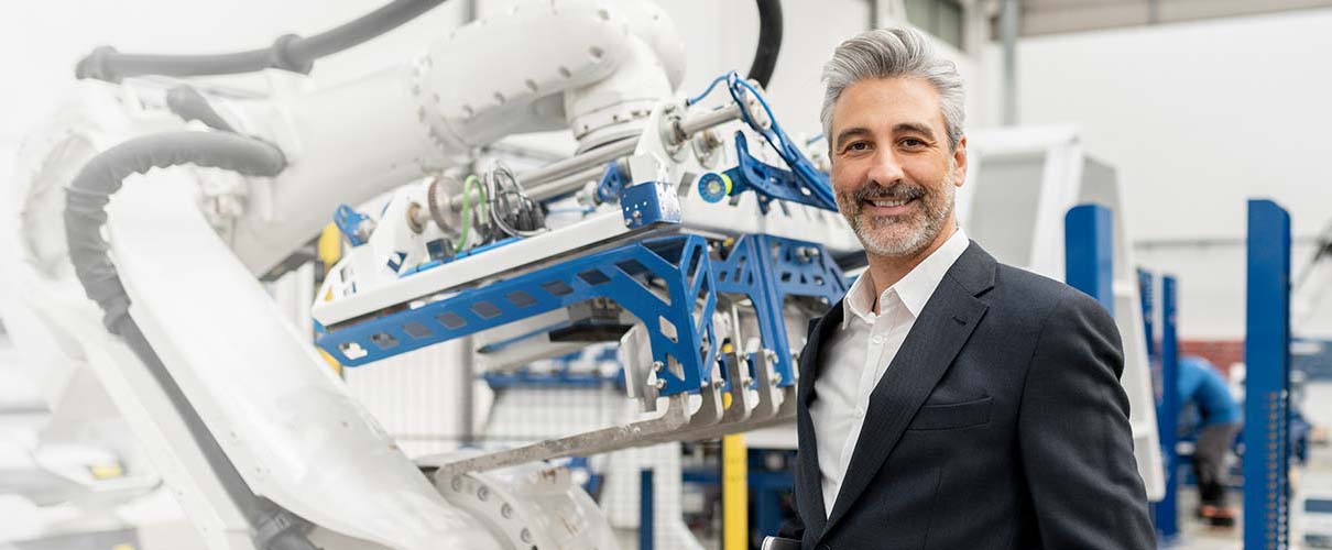 uśmiechnięty mężczyzna w nowoczesnej fabryce