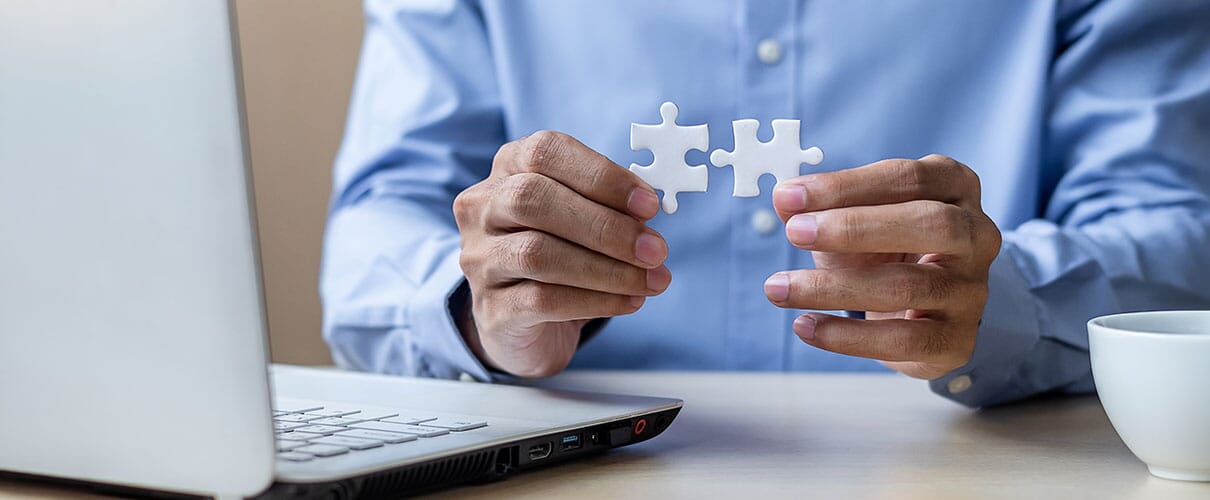 mężczyzna łączy 2 białe puzzle