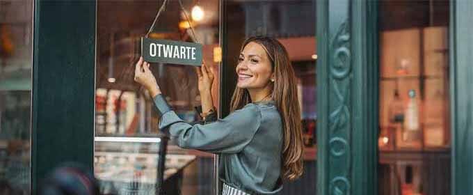 uśmiechnięta kobieta otwiera sklep