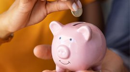 kobieta i mężczyzna, oszczędzający gotówkę do świnki skarbonki