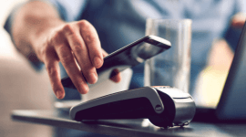 mężczyzna płacący zbliżeniowo telefonem z NFC