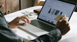 mężczyzna siedzący przy laptopie, robiący zakupy online