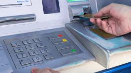 jak zmienić PIN - kobieta wkładająca kartę bankomatową do bankomatu