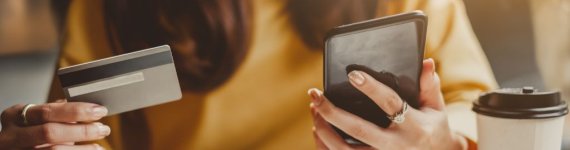 młoda kobieta z telefonem i kartą kredytową