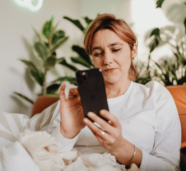 kobieta z telefonem w dłoni, zakładająca konto osobiste online