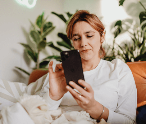 kobieta z telefonem w dłoni, zakładająca konto osobiste online