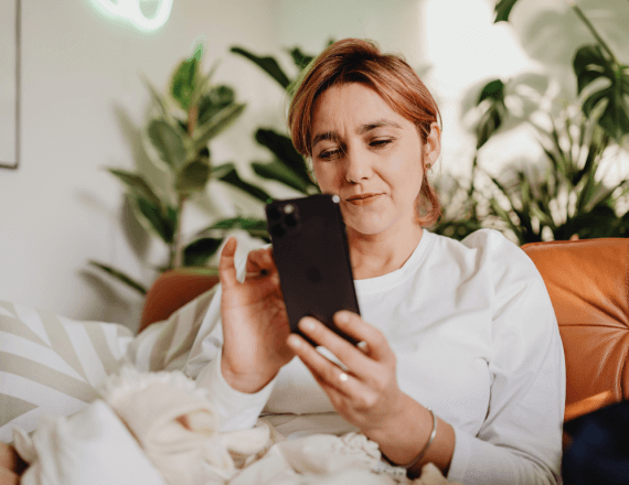 kobieta z telefonem w dłoni, zakładająca konto osobiste online
