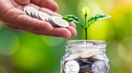 osoba wrzucająca monety do słoika - oszczędzanie