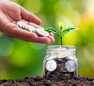 osoba wrzucająca monety do słoika - oszczędzanie