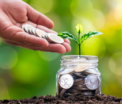 osoba wrzucająca monety do słoika - oszczędzanie