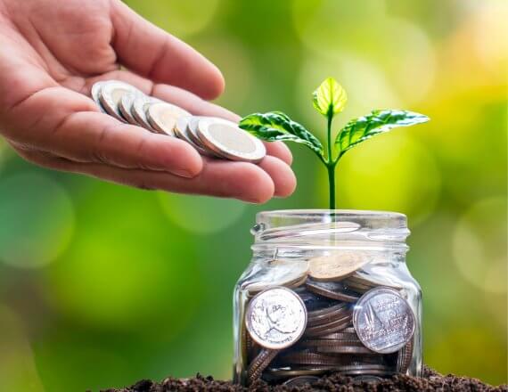 osoba wrzucająca monety do słoika - oszczędzanie