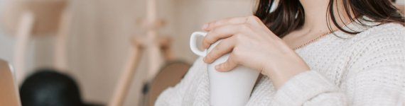 uśmiechnięta, młoda kobieta z laptopem, wnioskuje o kredyt konsolidacyjny online