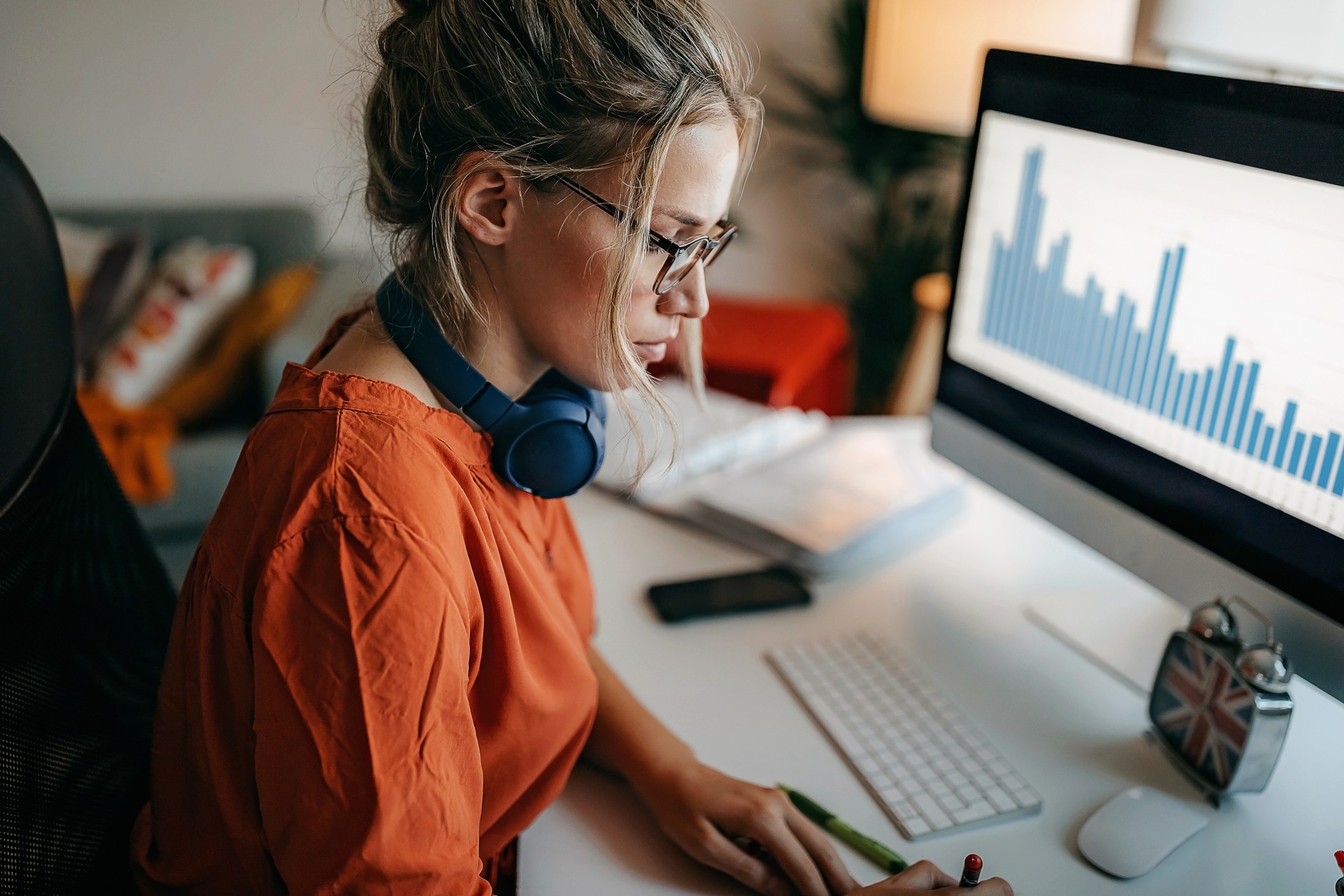Młoda kobieta, pracownik banku, siedzi przed komputerem podczas pracy zdalnej z domu.