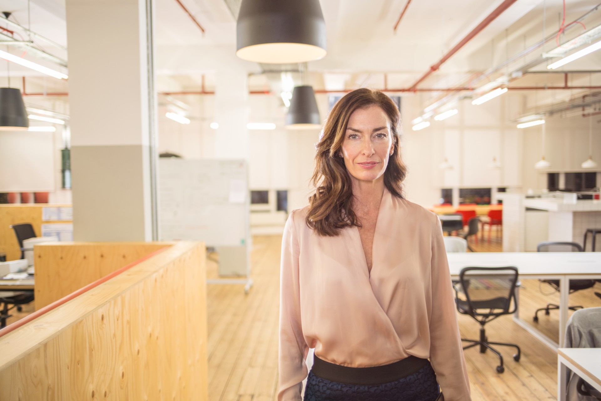 Kobieta, pracownik banku z obszaru Finanse w przestrzeni biurowej.