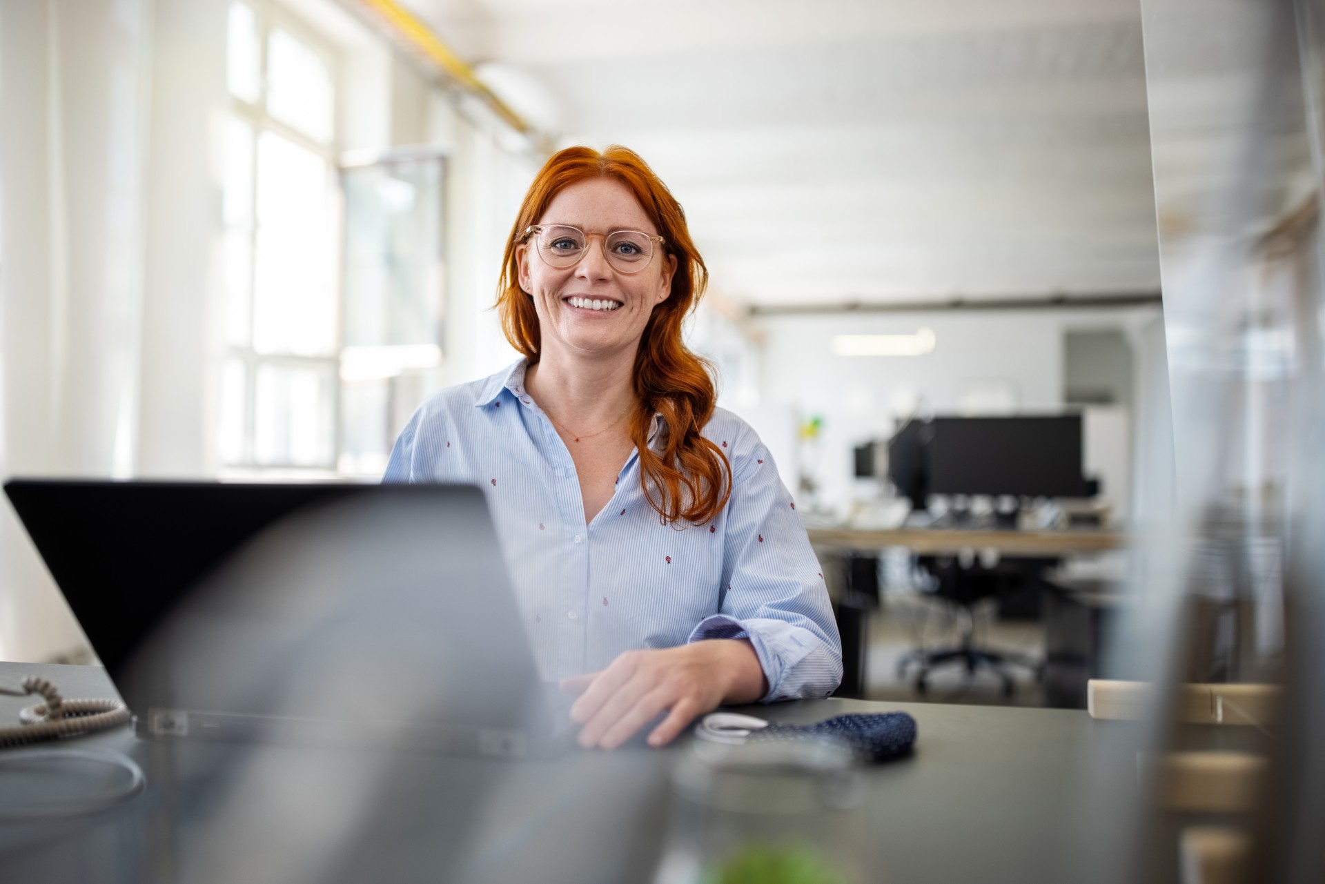 Kobieta, pracownik banku z obszaru IT siedzi przed komputerem.