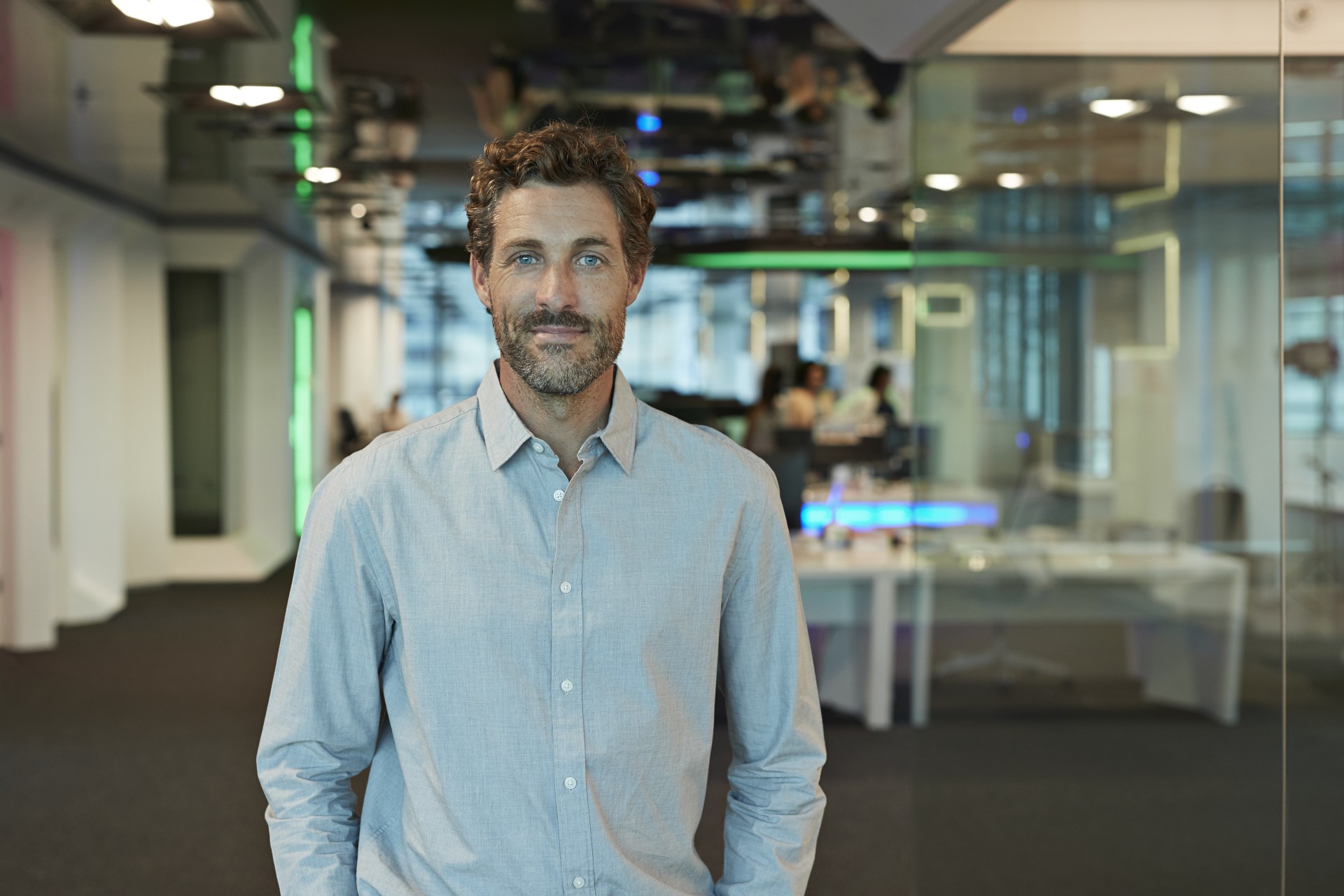 Mężczyzna, pracownik banku z obszaru Transformacja Zwinna przed salą konferencyjną w banku.